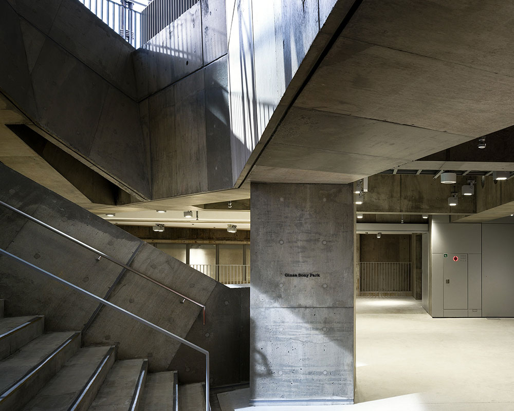 Sunlight pours down the stairway on the first basement floor through the open atrium.