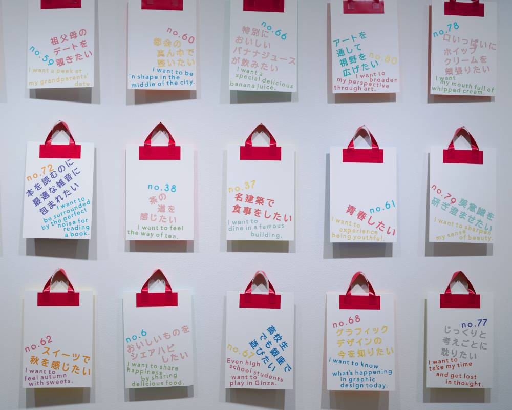 Exhibit. The wall is lined with cards on which are written things people want to do, like “I want to eat a meal in an architectural masterpiece.”