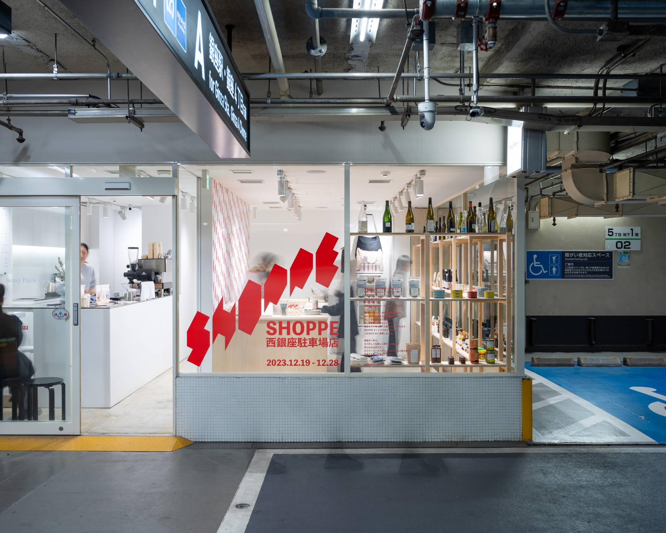 Exterior. The exhibition space has been turned into a kakuuchi (combined liquor store and bar)-style space with wooden shelves lined with food and drinks.