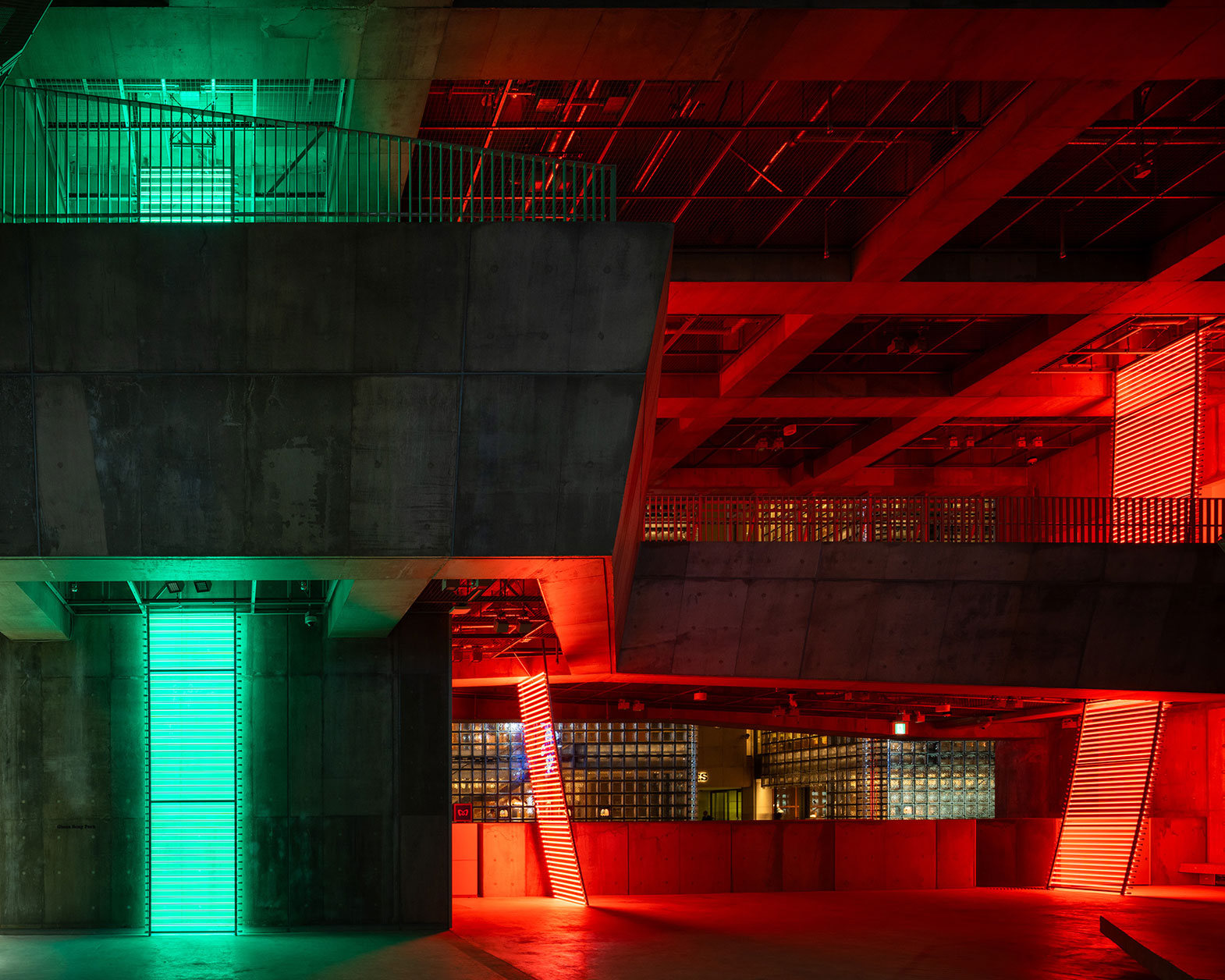 Exhibit. Green and red lights are shining in the concrete architectural space.